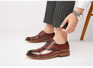 Detailed view of brown burnished leather Oxford shoes for men's professional business wear.