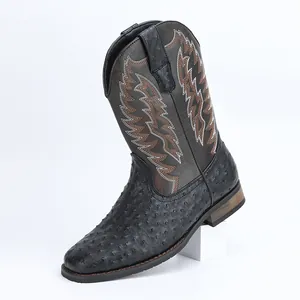 Vue détaillée d'une botte de cowboy noire avec texture d'autruche et broderie blanche