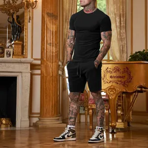 Completo da uomo con t-shirt nera a maniche corte e pantaloncini in ambiente interno di lusso