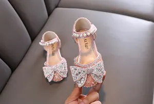 Elegantes zapatos de princesa rosa para niñas con pedrería brillante y lazo grande.