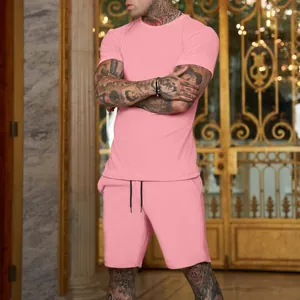 Completo estivo da uomo con t-shirt rosa a maniche corte e pantaloncini coordinati.