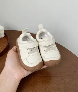Macro view of cream leather toddler walking shoes with soft brown anti-slip soles