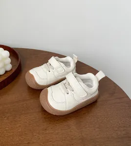 Detailed view of cream-colored British style toddler walking shoes with soft rubber soles