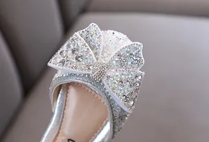 Detalle de primer plano del lazo de pedrería en zapatos de princesa para niñas