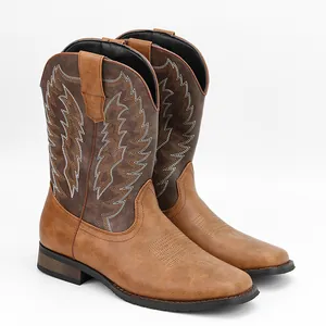 Gros plan sur des bottes de cowboy marron pour hommes avec des motifs de broderie blancs.