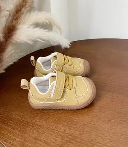 Detailed view of yellow British style baby walking shoes with soft rubber soles
