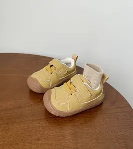 Close-up of yellow British-style leather toddler shoes with durable soft rubber soles