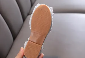 Detalle en primer plano de la suela de goma antideslizante para zapatos de niña plateados