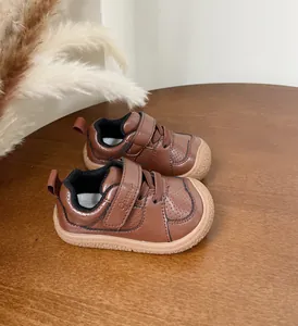 Detail of brown leather toddler walker shoes with velcro straps and soft soles.