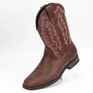 Detalle de botas vaqueras western marrones con bordado blanco en el eje de color rojo