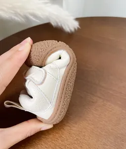 Close-up showing the extreme flexibility and soft sole of white toddler walking shoes