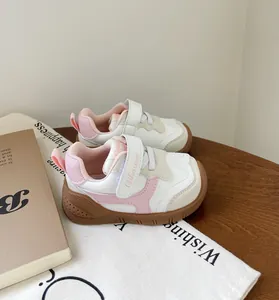 Vista de detalle de zapatos para caminar de bebé rosa y blanco con suela de goma