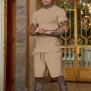 Vista dettagliata del completo t-shirt e pantaloncini sportivi beige per uomo sul modello