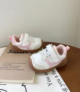 Vista detallada de zapatillas rosas y blancas para niños con suela de goma blanda