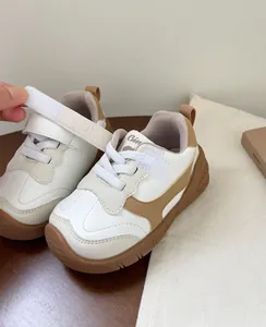 Detalle de zapatillas blancas y marrones para bebé con cierre de velcro ajustable