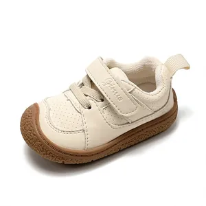 Cream white baby toddler walking shoes with soft rubber sole and Velcro closure strap.
