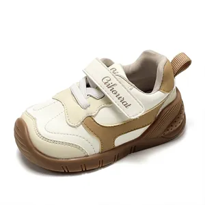 Zapatos de andar para bebés con suelas blandas y velcro en color crema y café.