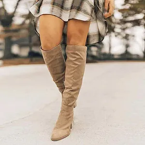 Close-up of taupe suede high heel boots with sleek pointed toe design for autumn winter.