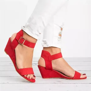 Side view detail of women's red suede wedge sandals featuring adjustable ankle buckle