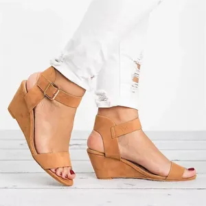 Side view of tan suede wedge sandals with ankle buckle and peep toe design