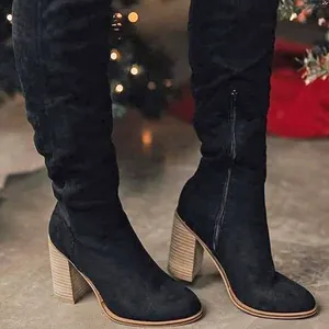 Black suede over-the-knee boots with chunky wooden heels and side zipper detail.