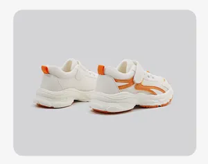 Detailansicht der weiß-orangen atmungsaktiven Mesh-Lauflernschuhe für Babys mit weicher Sohle