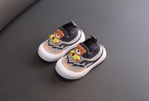 Detalle de oso decorativo en zapatos de malla fly-knit transpirables para niños