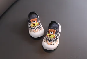 Vista detallada de zapatos de punto transpirables para niños con un lindo osito.