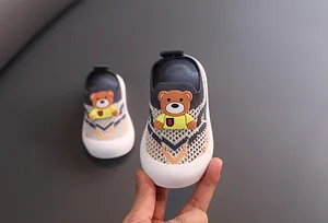 Vista detallada de zapatos de punto para niños con un adorable diseño de oso en 3D relajado