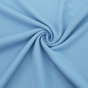 Primer plano de tela de punto gofrado azul claro que muestra su textura y tejido suave.