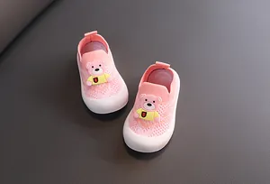 Primer plano detallado de zapatos de punto rosa para bebé con un diseño de oso 3D