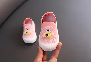 Primer plano de zapatillas de punto rosa para niños con malla y lindo decorado de oso 3D