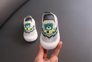 Detalle de zapatos transpirables de punto para niños con un lindo oso de dibujos