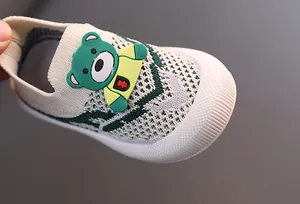 Detalle en primer plano de un lindo oso verde en zapatillas de punto infantiles
