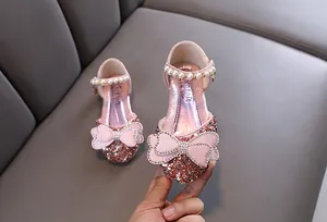 Detail of pink girl's princess shoe featuring sparkling sequins and a rhinestone bow.