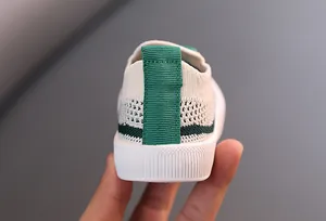 Primer plano del talón de una zapatilla de punto para niños con tira verde y textura