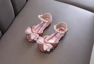 Detailed close-up of pink girls princess shoes featuring sparkling rhinestones and elegant pearl straps