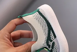Primer plano de la tela fly-knit flexible en zapatillas ligeras y transpirables para niños