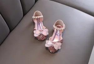 Pink glittery princess shoes for girls with pearl straps and bow details