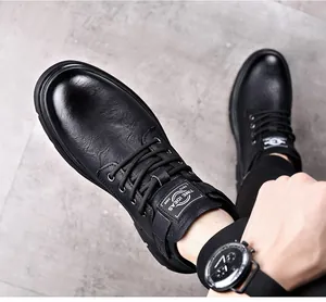 Close-up of black vintage leather men's work boots with lace-up detail and tongue logo