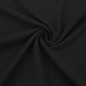 Vista macro detallada que muestra la textura de punto tipo gofre negro de este polo para hombres