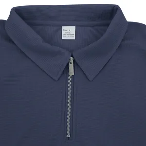 Dettaglio ravvicinato della polo blu navy in tessuto nido d'ape con colletto a zip
