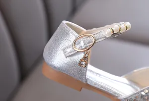 Detailed close-up view of silver glitter girl's princess shoe featuring pearl strap