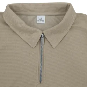 Primer plano detallado del polo de hombre en punto de gofre caqui con cremallera