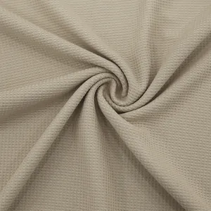Vista macro detallada del tejido de punto gofrado beige para polos casuales de hombre