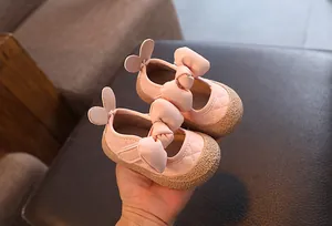 Gros plan de chaussures de marche rose pour bébé avec un grand nœud