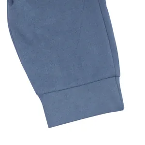 Vue macro de l'ourlet de pantalon en daim bleu avec coutures fines et texture douce