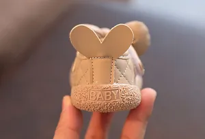 Détail d'une chaussure bébé beige avec semelle souple et détail de talon en cœur
