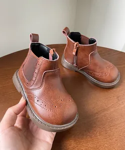 Primer plano de los detalles de los patrones brogue en botas de cuero marrón para niños.