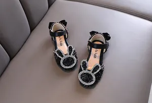 Detail of black girl's princess shoes with sparkly rhinestone bunny ears and bow.